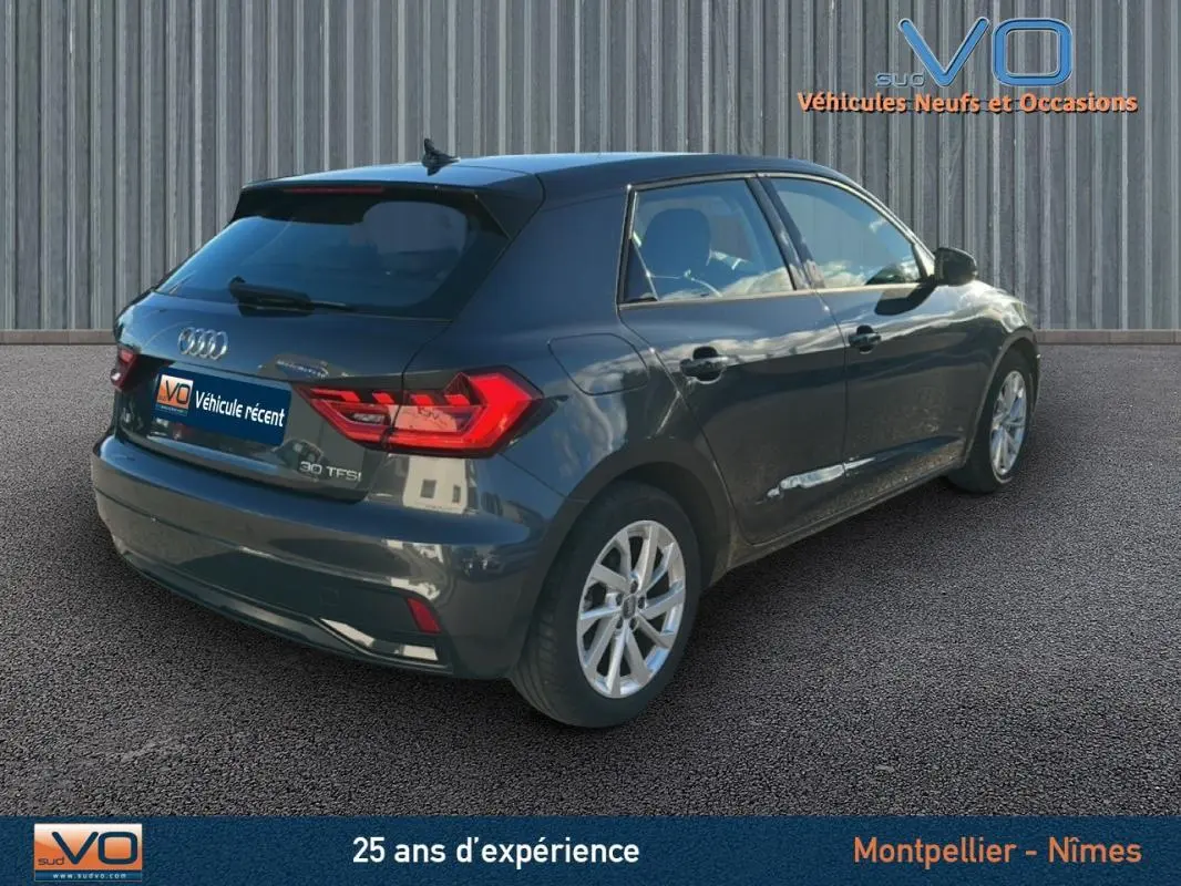 Audi A1 Sportback gris foncé vue 3/4 arrière droit, jantes 16 pouces et feux arrière LED visibles.