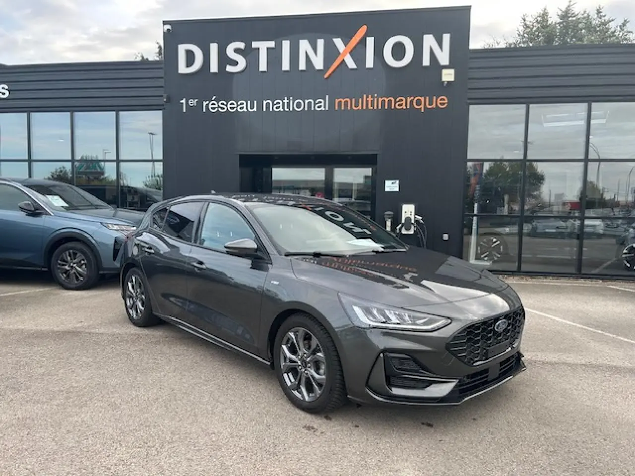 Ford Focus IV ST-Line X gris Magnetic Metal vue 3/4 avant avec calandre noire et jantes alliage 17 pouces.