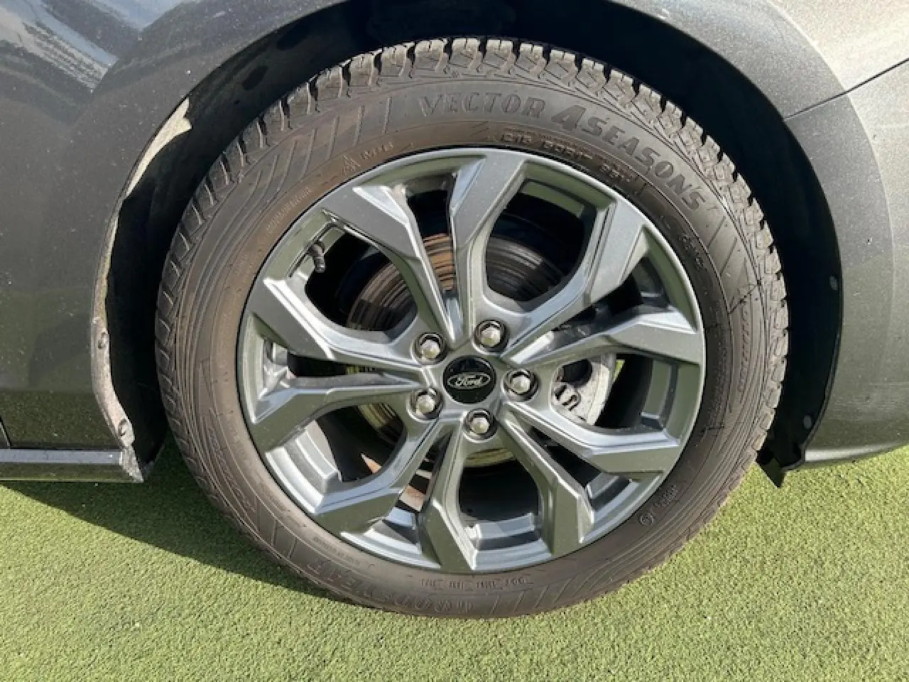 Gros plan sur la roue avant droite de la Ford Focus IV gris magnetic avec jante alliage 17 pouces à 5 branches.