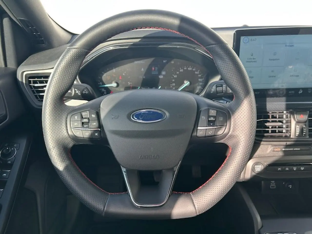 Vue intérieure frontale du volant ST-Line noir avec surpiqûres rouges et combiné numérique de la Ford Focus IV gris Magnetic Metal.