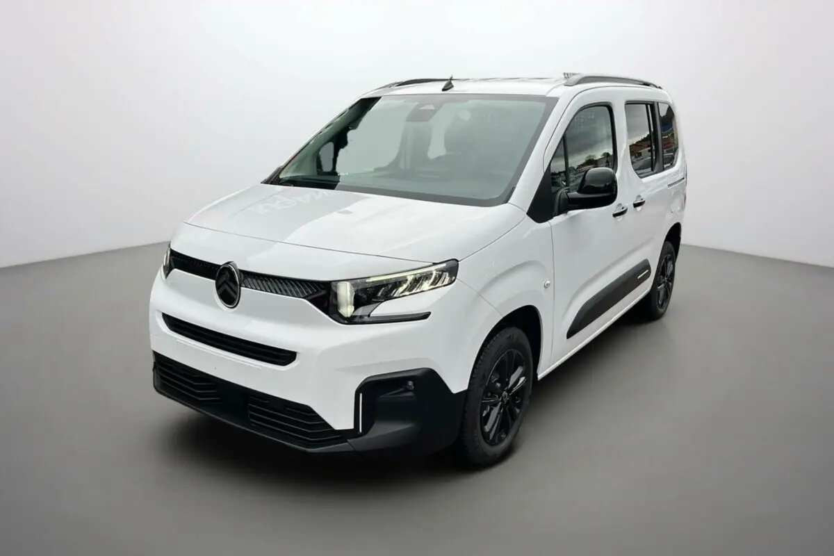 Citroën Berlingo Kaolin white en 3/4 avant droit, avec barres de toit et jantes noires distinctives.