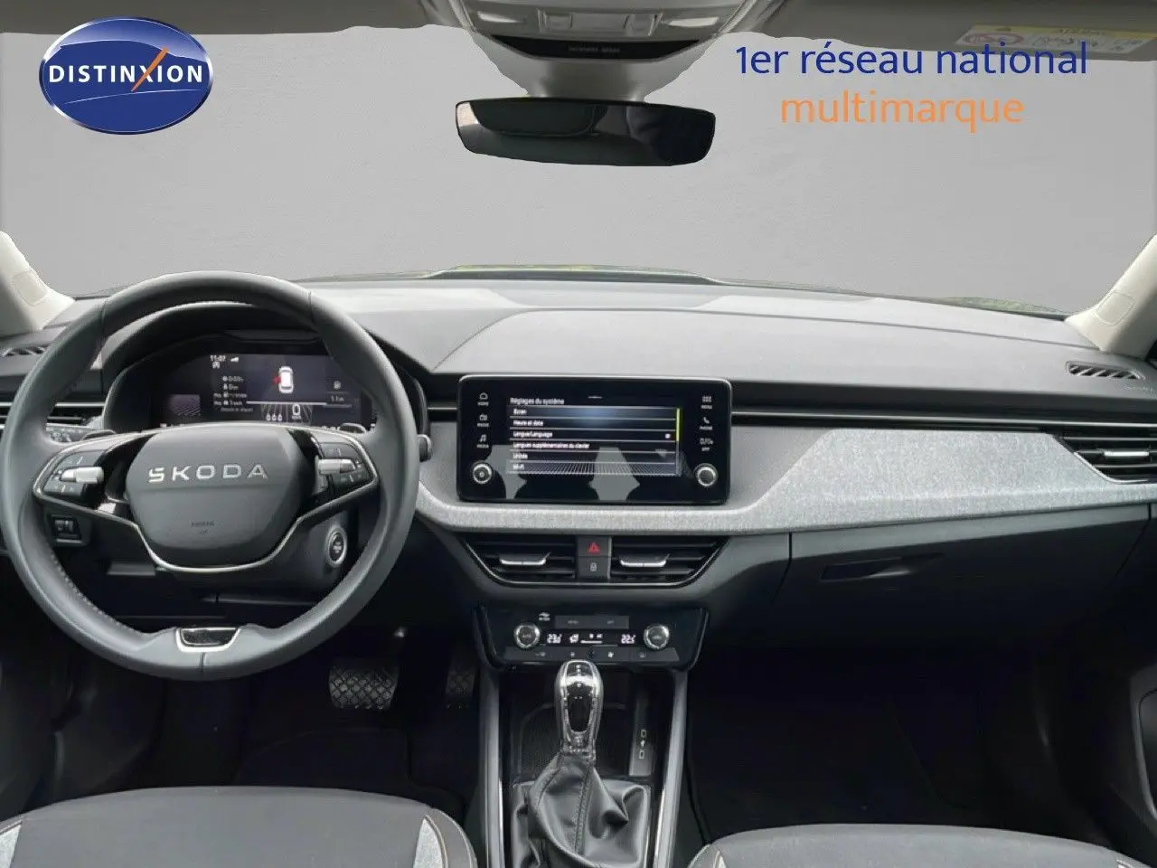Vue frontale de l'intérieur du Skoda Kamiq 2025 gris graphite, avec tableau de bord moderne et écran tactile central.