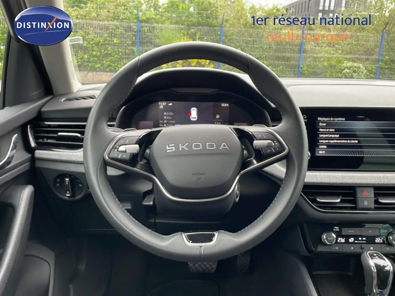 Vue intérieure centrée sur le volant SKODA d’un KAMIQ 2025, avec tableau de bord digital et écran tactile gris graphite.