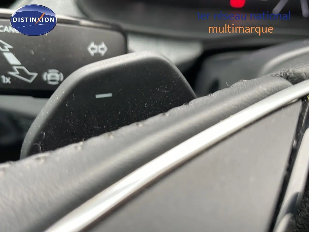 Gros plan sur la palette de changement de vitesse du volant d’un Skoda Kamiq gris graphite, intérieur noir.