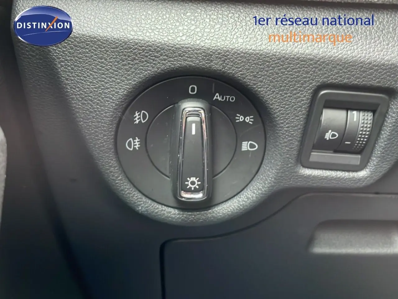 Gros plan sur le bouton de commande des phares dans l'habitacle du Skoda Kamiq gris graphite 2025.