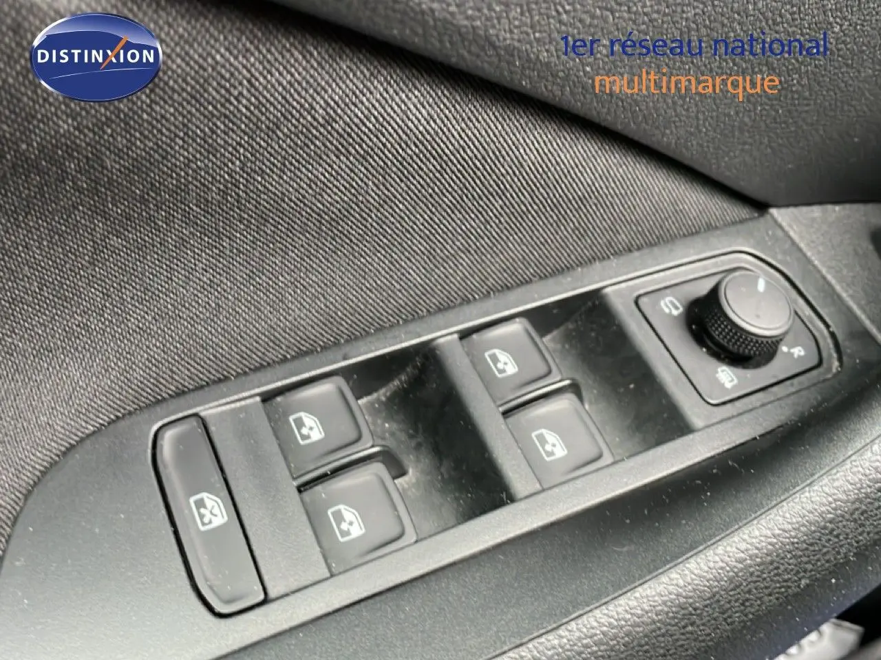 Gros plan sur les commandes des vitres électriques et réglages des rétroviseurs côté conducteur du Skoda Kamiq gris graphite.