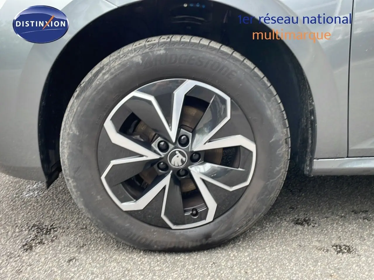 Gros plan sur la roue avant droite du Skoda Kamiq gris graphite métal, mettant en valeur la jante au design moderne.