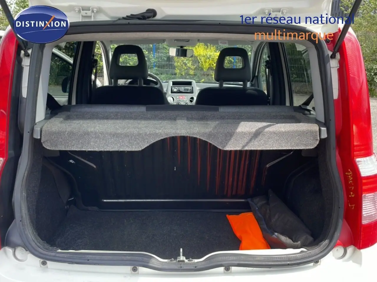 Vue arrière du coffre ouvert d'une Fiat Panda blanche de 2011, montrant l'intérieur et les sièges noirs.