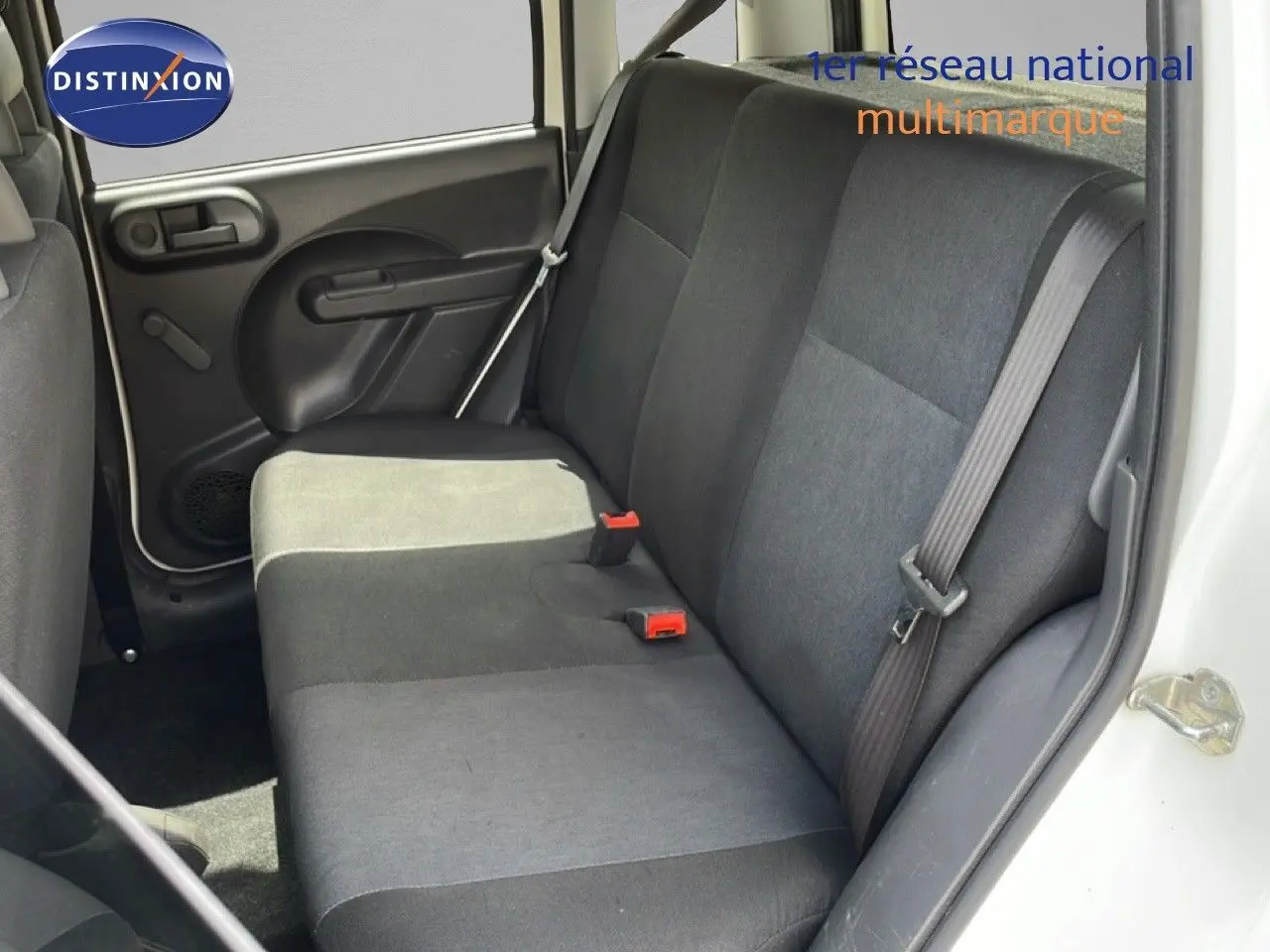 Vue intérieure côté droit sur la banquette arrière noire d’une Fiat Panda blanche avec porte ouverte.