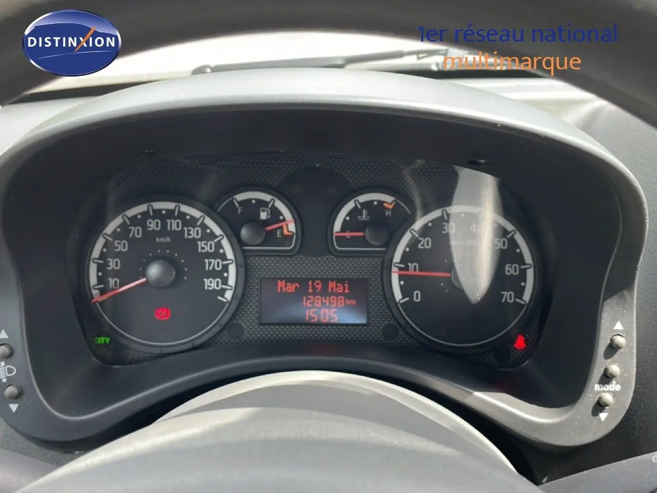 Vue rapprochée du tableau de bord noir de la Fiat Panda blanche, affichant compteur et jauges numériques.