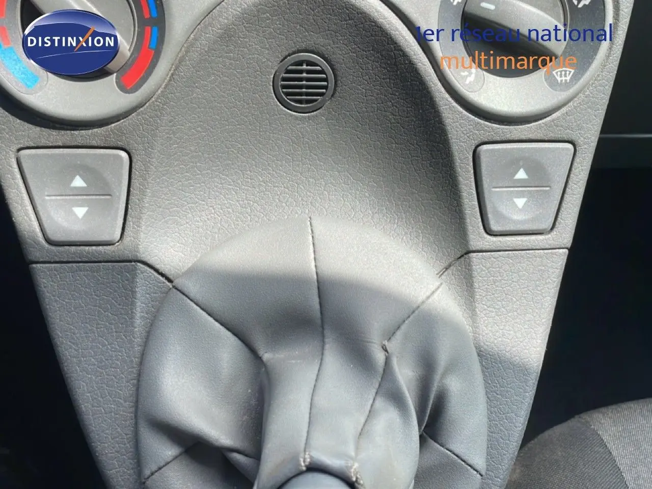 Gros plan sur la console centrale de la Fiat Panda blanche, mettant en valeur le levier de vitesses manuel et les commandes de climatisation.