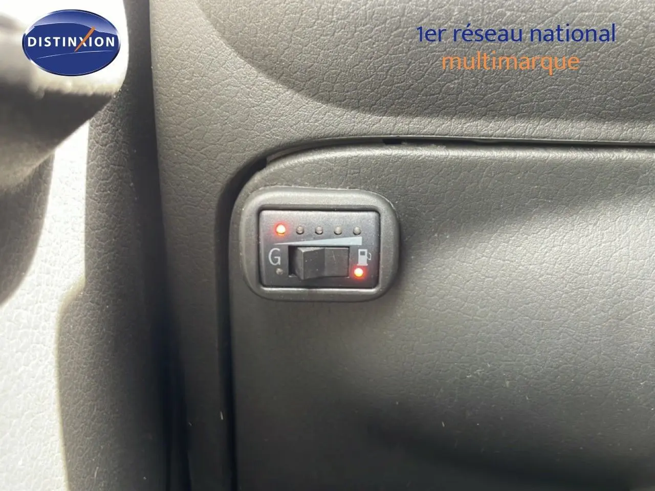 Détail du tableau de bord montrant l'interrupteur de sélection essence/GPL dans une Fiat Panda blanche 2011.