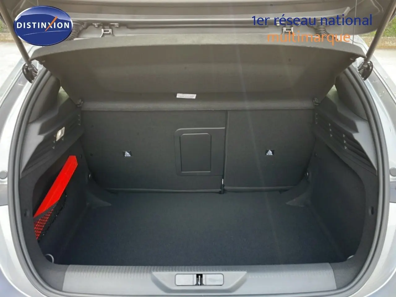 Coffre ouvert vu de l'arrière d'une Peugeot 308 gris Artense métal, espace de chargement propre et spacieux.