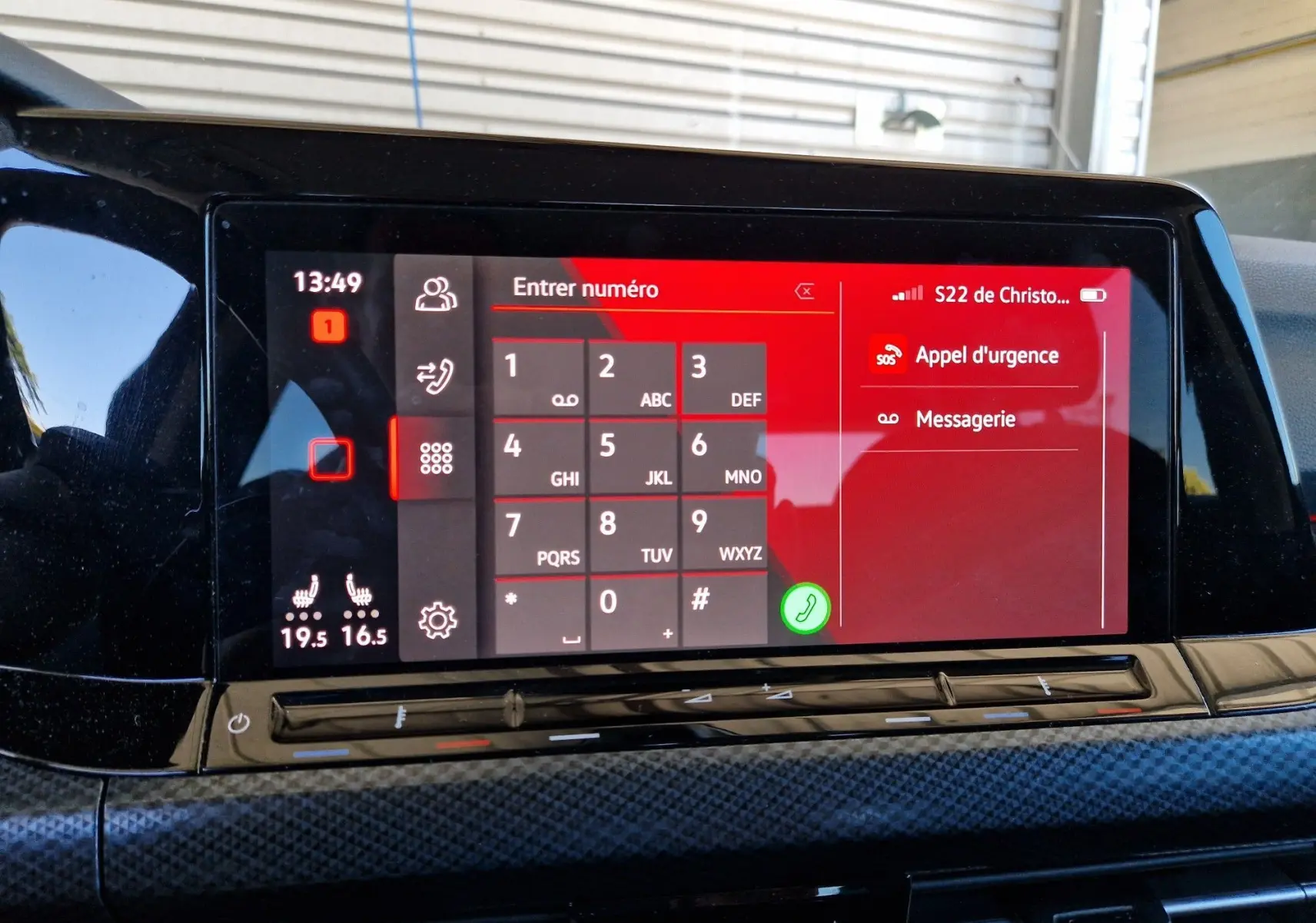 Écran tactile central de la Volkswagen Golf VIII noire, affichant le clavier téléphonique et options d'appel d'urgence.