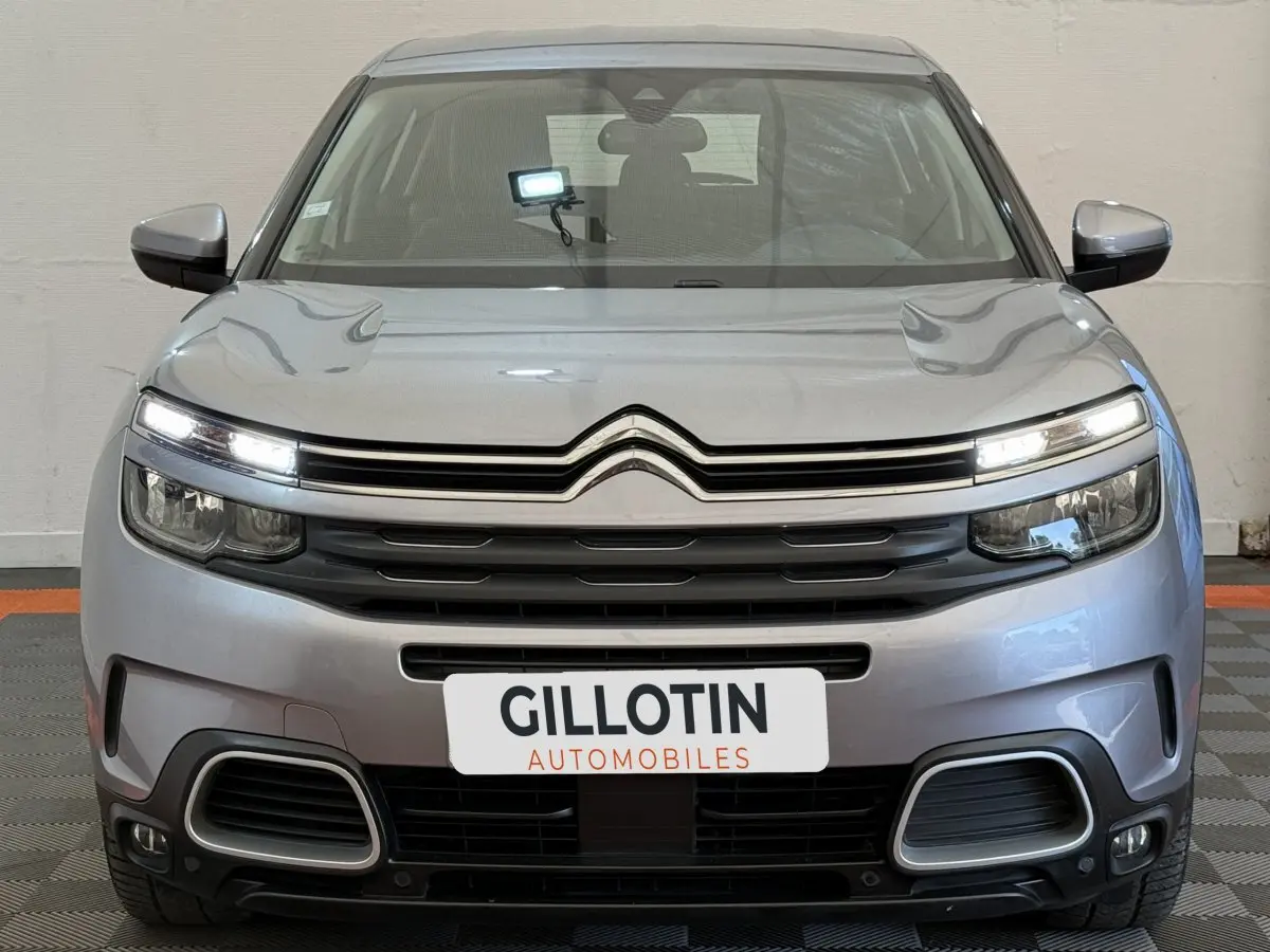 Vue frontale d'un Citroën C5 Aircross gris clair avec feux LED allumés et calandre noire distinctive.