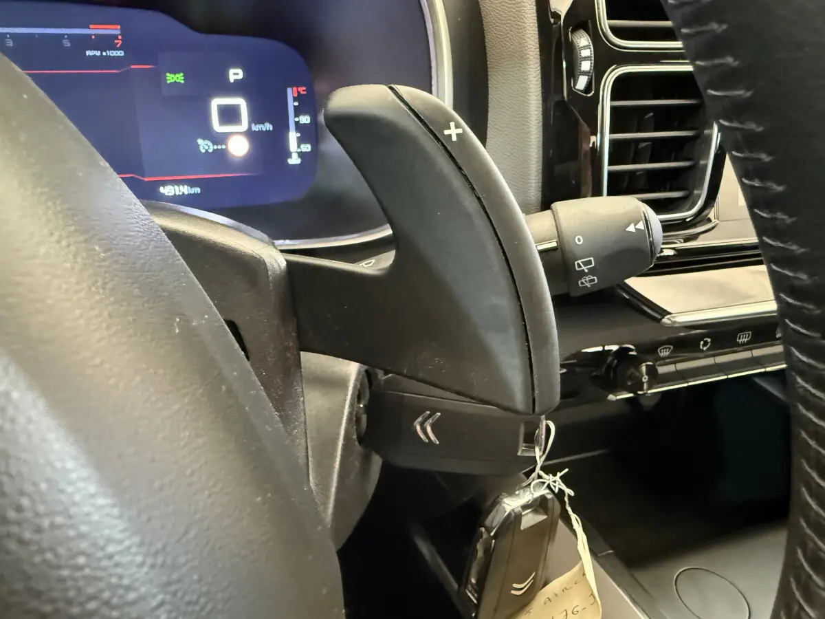 Gros plan sur la commande de palette de vitesse + du volant cuir et tableau de bord numérique du Citroën C5 Aircross gris clair 2020.