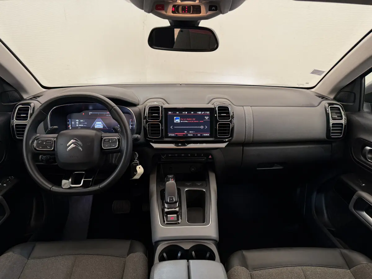 Vue intérieure frontale du tableau de bord gris foncé du Citroën C5 Aircross avec écran tactile central et volant multifonctions.