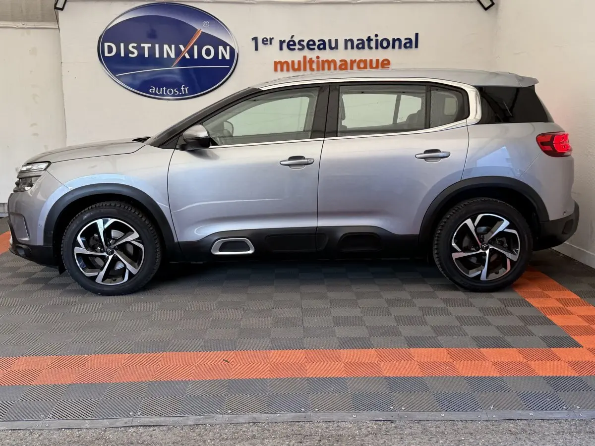 Profil droit d'un Citroën C5 Aircross gris clair 2020 avec jantes alliage et toit noir contrasté.