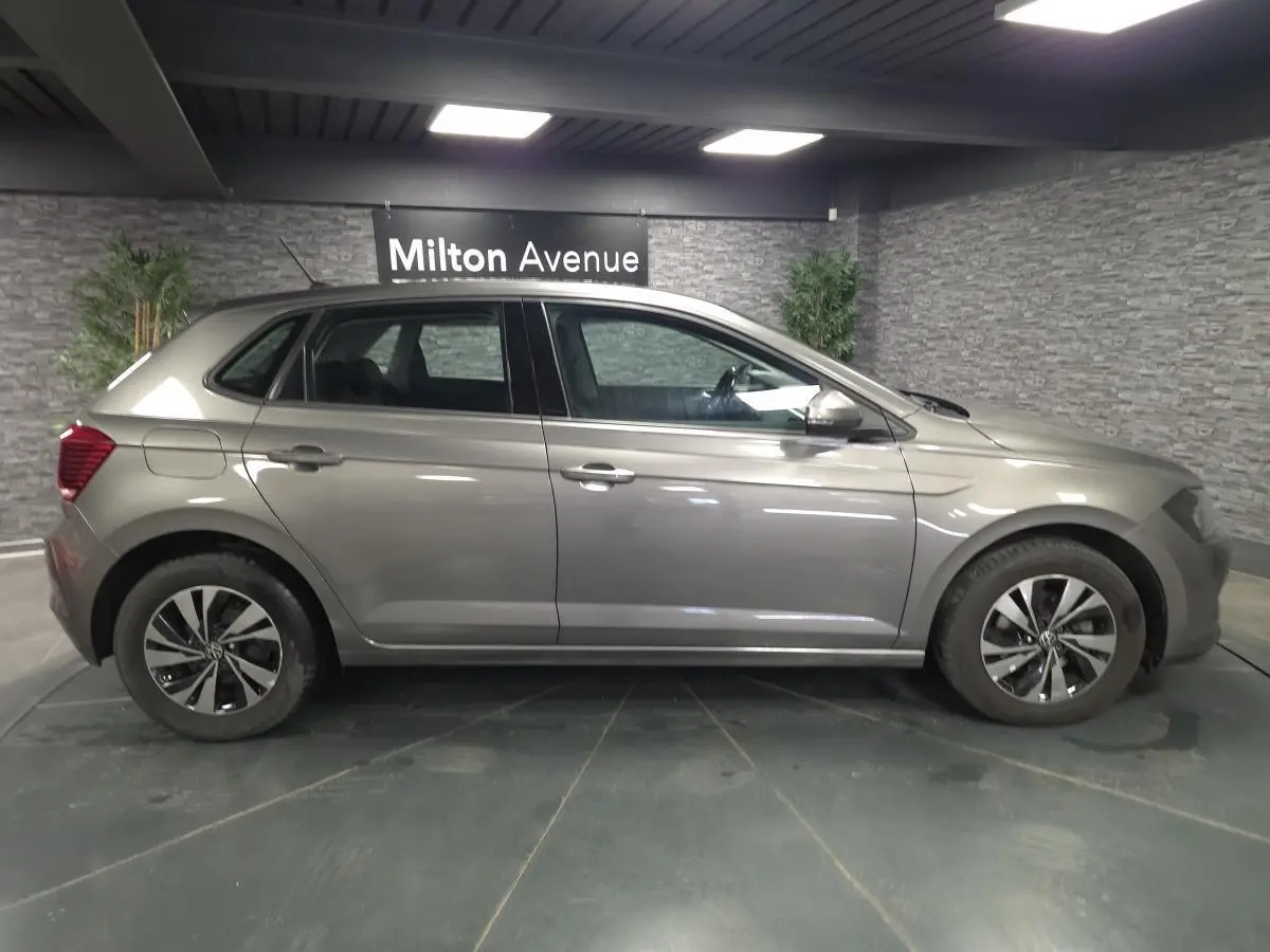 Profil droit d'une Volkswagen Polo gris métallisé 2020 avec jantes alliage 15 pouces en intérieur showroom.