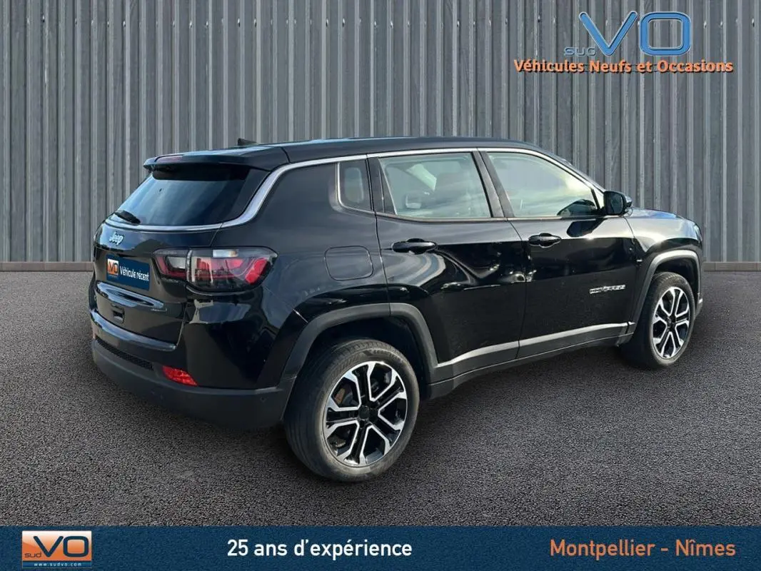 Vue 3/4 arrière droite d'un Jeep Compass noir 2024 avec jantes alliage 18 pouces et vitres teintées.