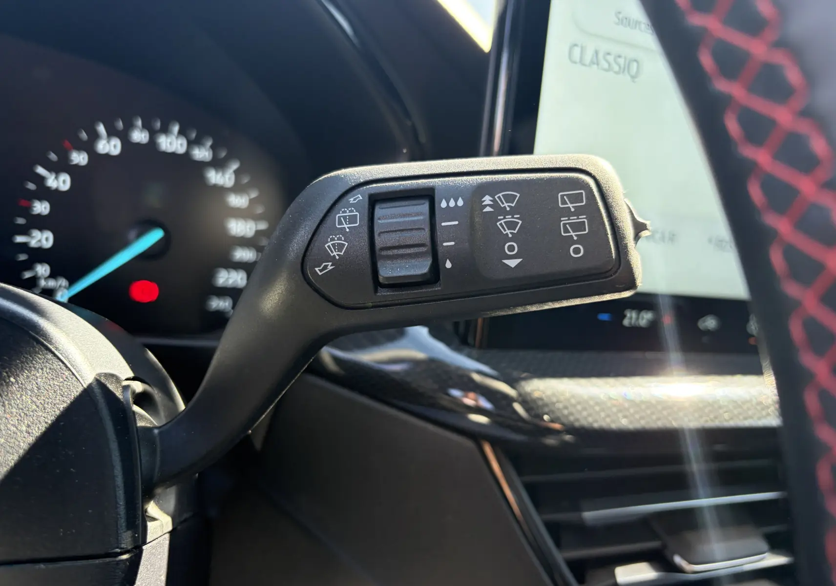 Gros plan sur la commande des essuie-glaces dans l'habitacle noir avec surpiqûres rouges de la Ford Focus IV ST-Line X.