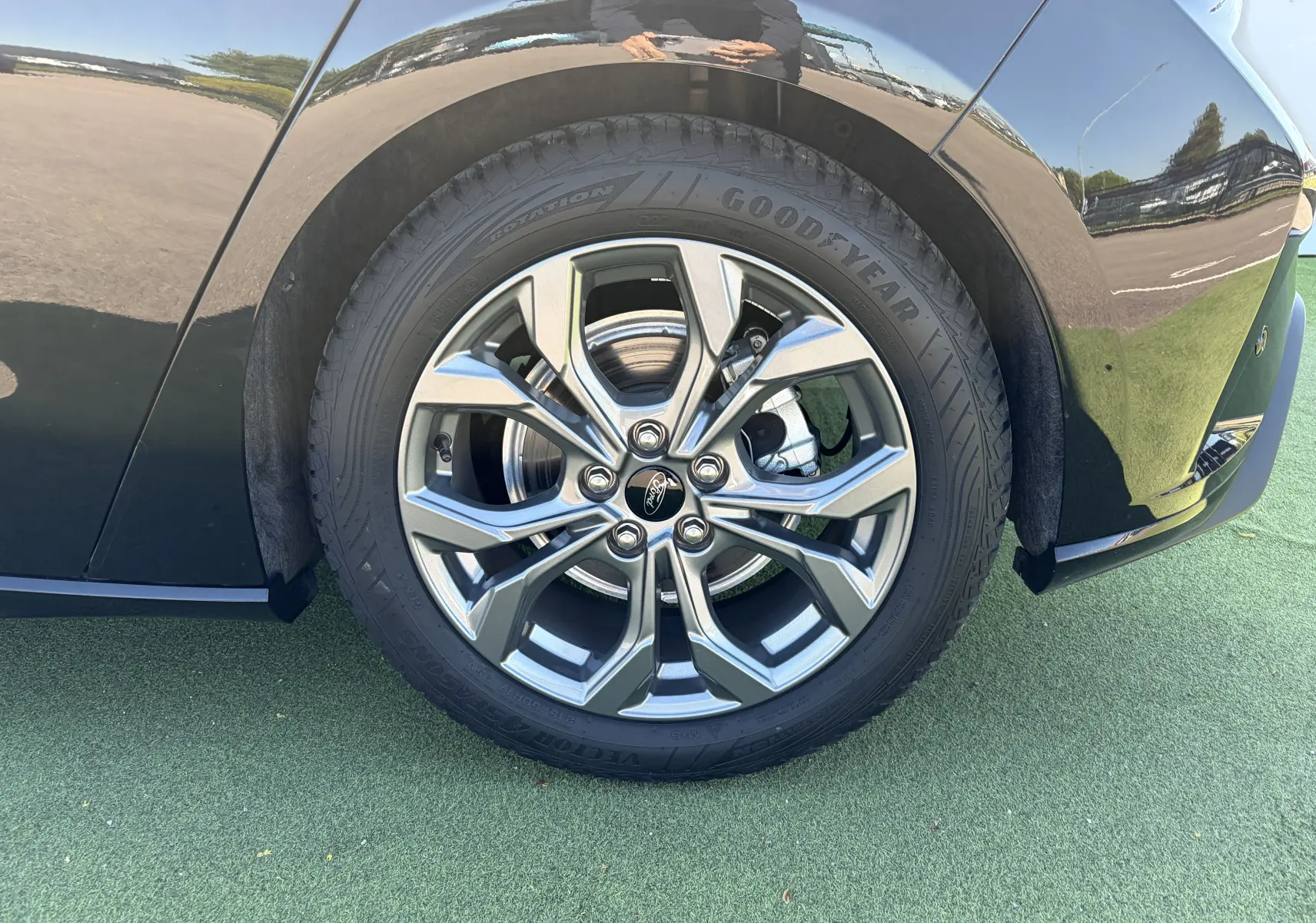 Gros plan sur la roue avant droite de la Ford Focus IV noire Agate avec jante alliage 17'' à 5 branches.