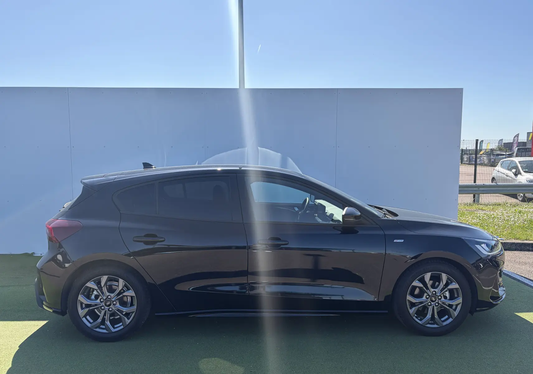 Ford Focus IV 1.5 EcoBlue noire vue de profil côté gauche, avec jantes alliage et vitres surteintées.