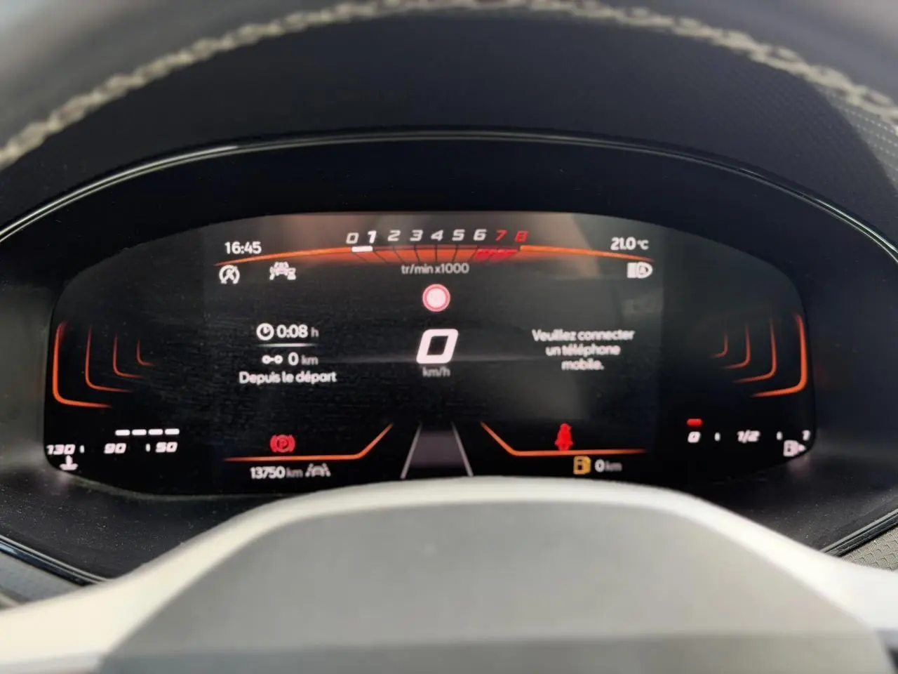 Vue rapprochée du combiné d'instruments digital du SEAT Arona TSI 115 Style, affichage rouge et noir.