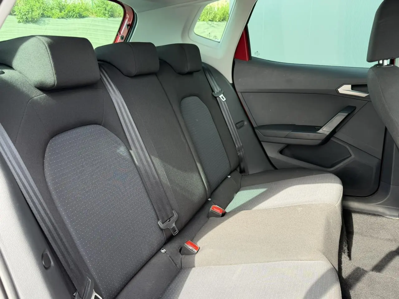 Vue intérieure de la banquette arrière noire du SEAT Arona 2025, côté droit avec ceintures de sécurité visibles.