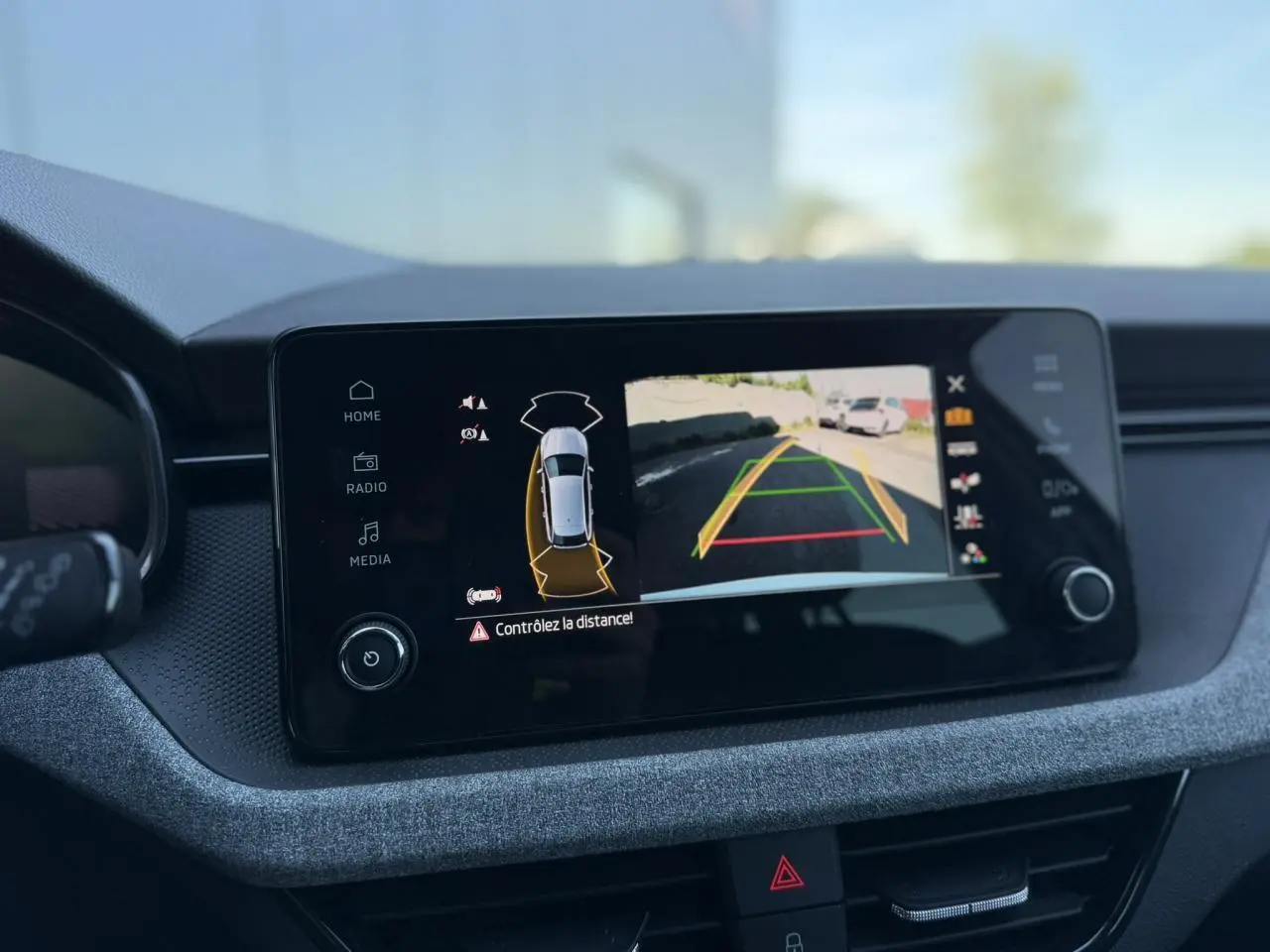 Écran central de la Skoda Scala blanc Glacier affichant la caméra de recul avec guidage dynamique.