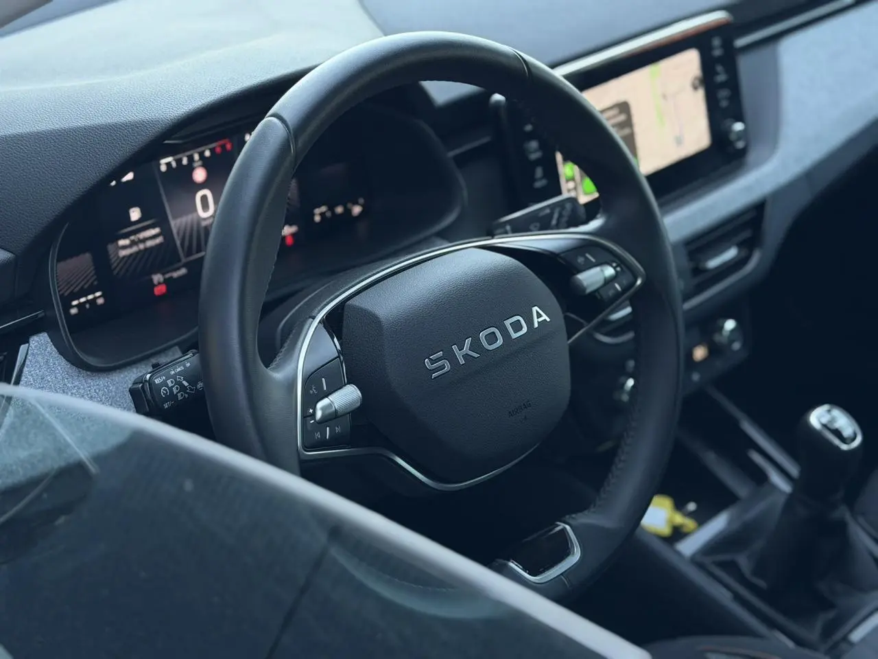 Vue rapprochée de l’intérieur d’une Skoda Scala 2025, volant cuir multifonctions et écran tactile central visible.