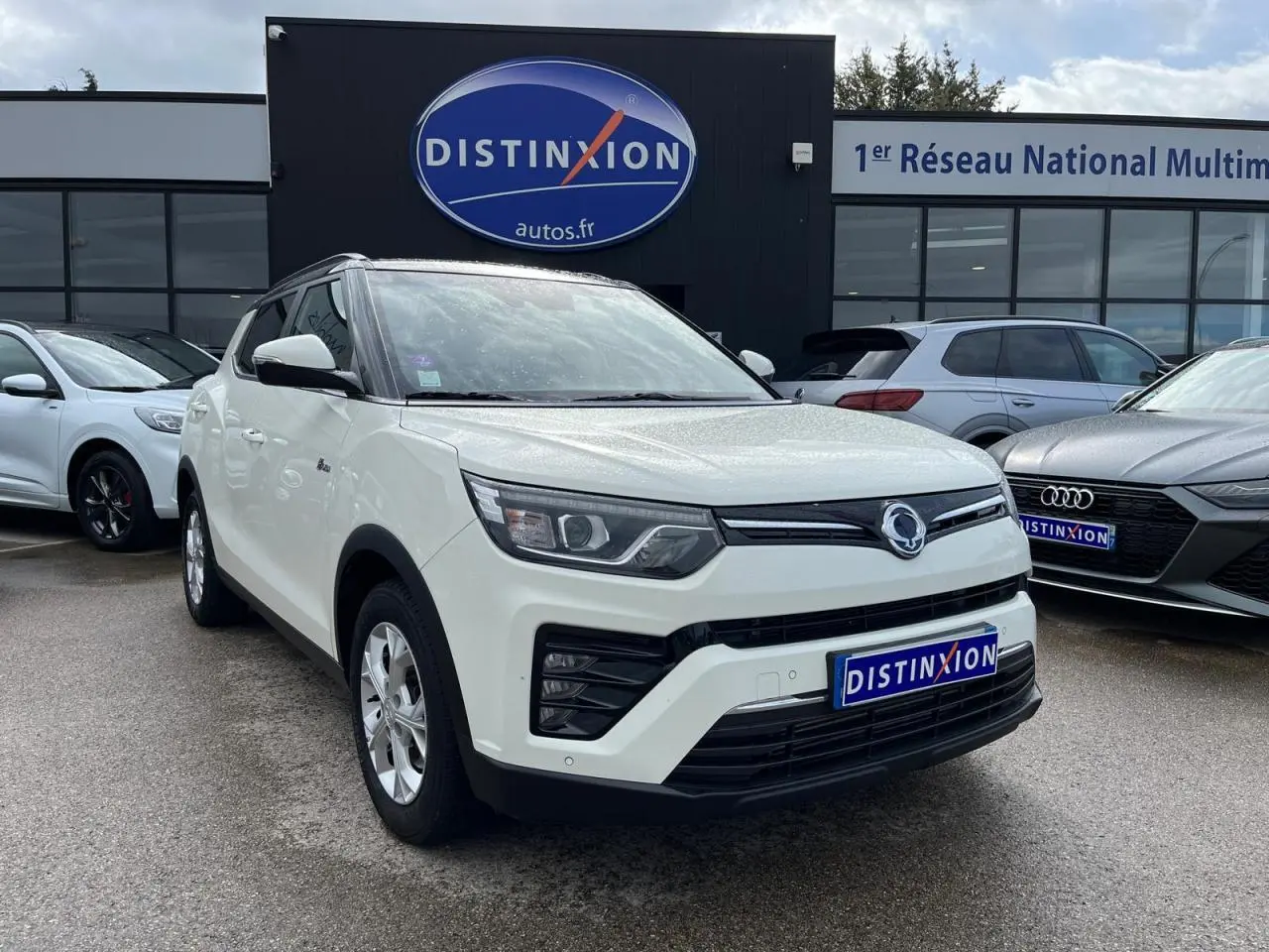 Vue 3/4 avant d'un SsangYong Tivoli blanc 2021 avec jantes alliage 16'' et calandre noire distinctive.