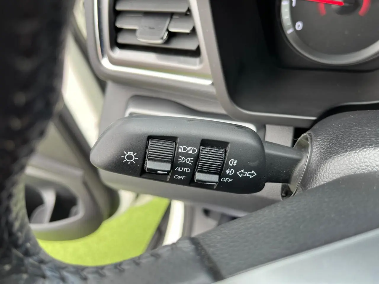 Gros plan sur la commande des phares et clignotants à gauche du volant d’un SsangYong Tivoli blanc de 2021.