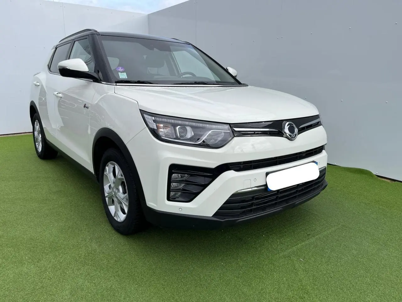 Vue 3/4 avant droite du SsangYong Tivoli blanc 2021 avec jantes alliage et toit noir contrasté.