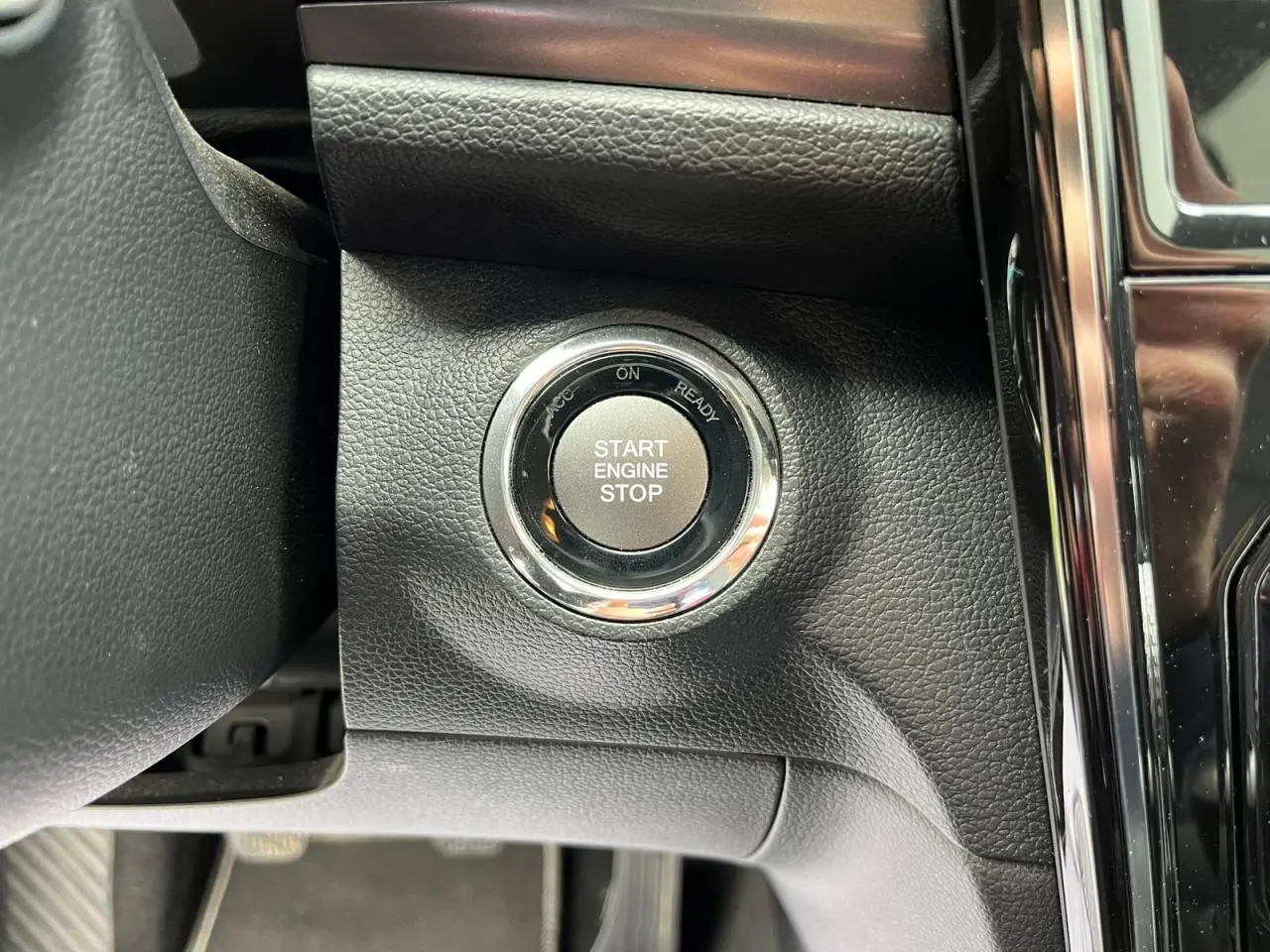 Gros plan sur le bouton Start Engine Stop du tableau de bord noir du SsangYong Tivoli blanc 2021.