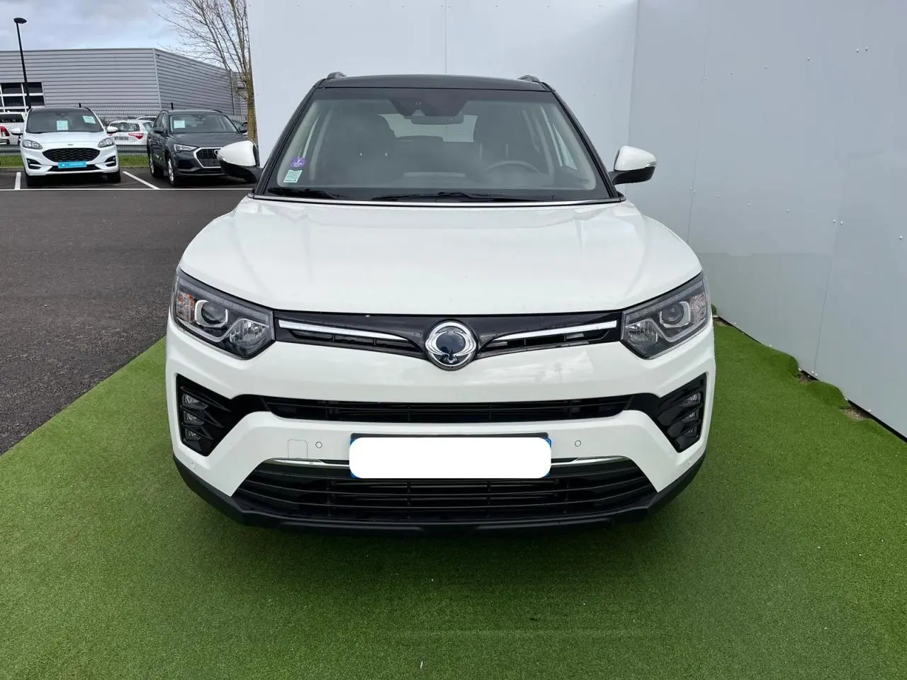 Vue frontale d'un SsangYong Tivoli blanc 2021 avec calandre noire et phares LED distinctifs.