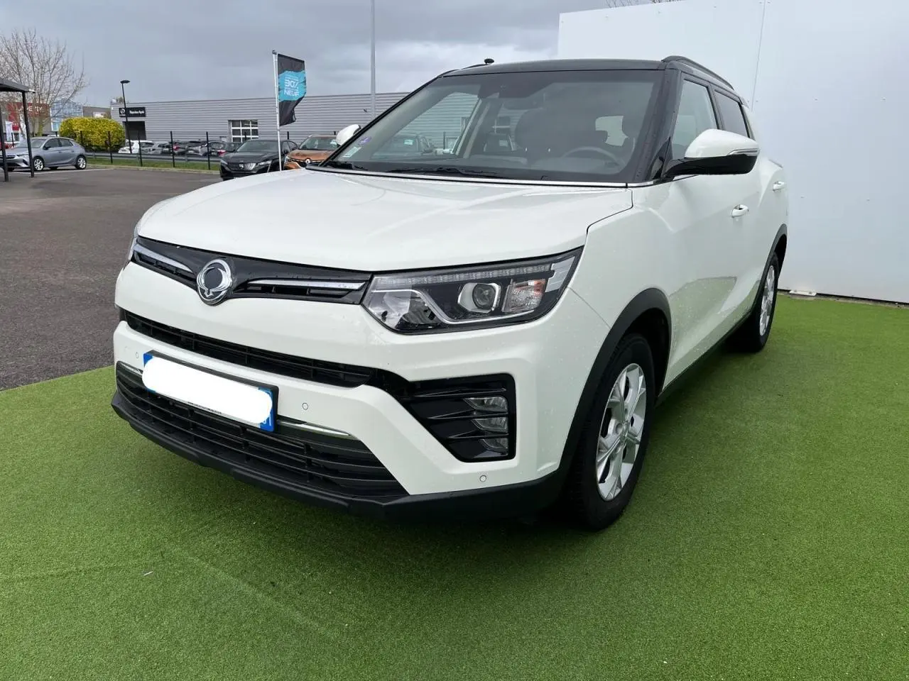 Vue 3/4 avant d’un SsangYong Tivoli blanc avec toit noir, jantes alliage 16 pouces et rétroviseurs blancs.