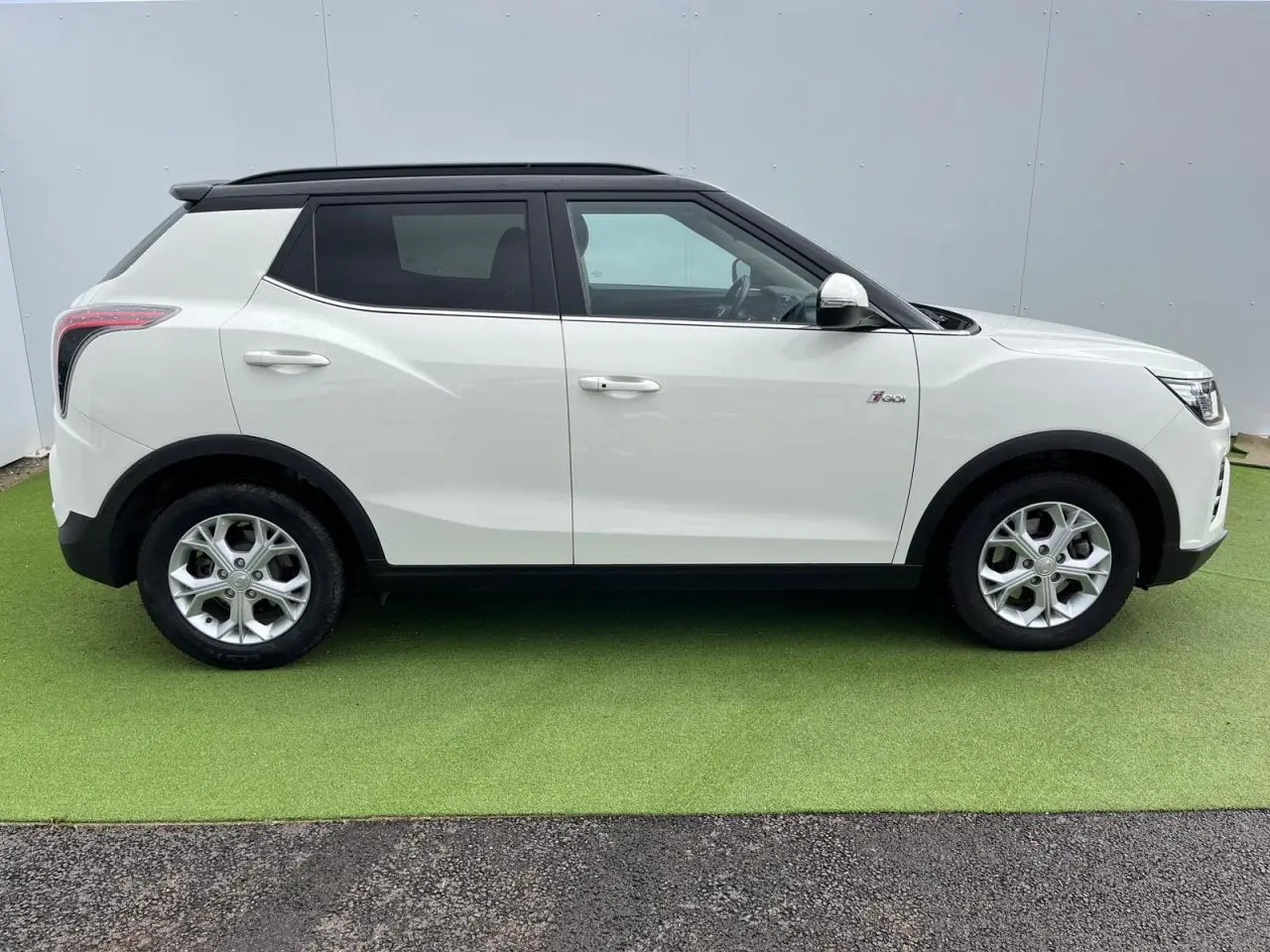 Vue de profil côté gauche d'un SsangYong Tivoli blanc avec toit noir et jantes alliage 16 pouces.