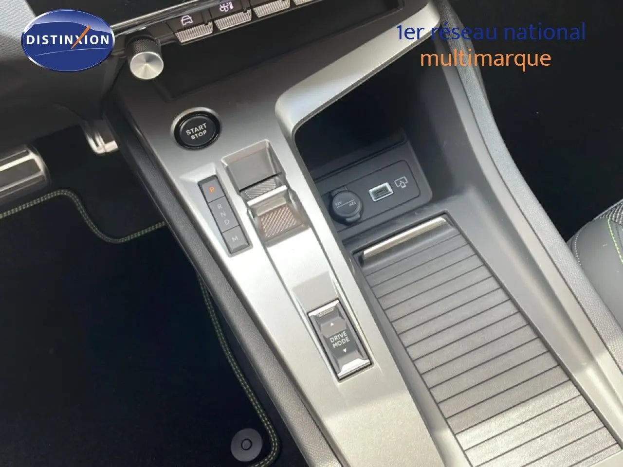 Vue rapprochée de la console centrale grise avec bouton start/stop et commande de boîte automatique sur Peugeot 308 hybride.