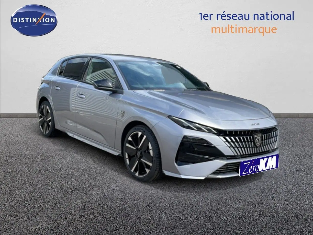 Peugeot 308 gris Artense métal en vue 3/4 avant droit, avec calandre distinctive et jantes noires bicolores.