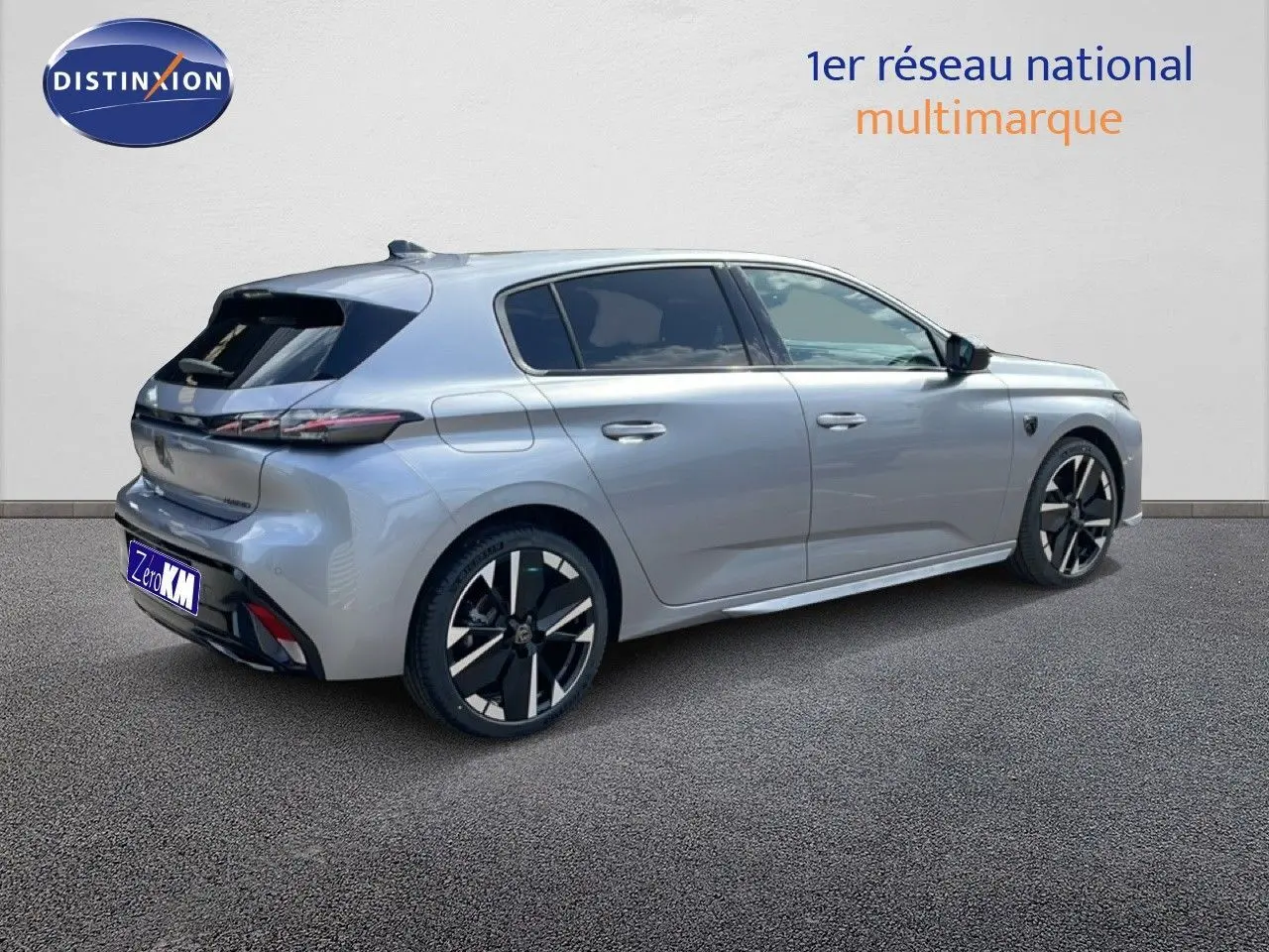Vue 3/4 arrière droite d'une Peugeot 308 gris Artense métal avec jantes noires et détails modernes.