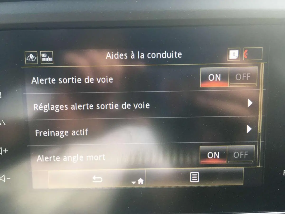 Écran tactile intérieur du Renault Kadjar 2020 affichant les aides à la conduite activées, vue rapprochée.