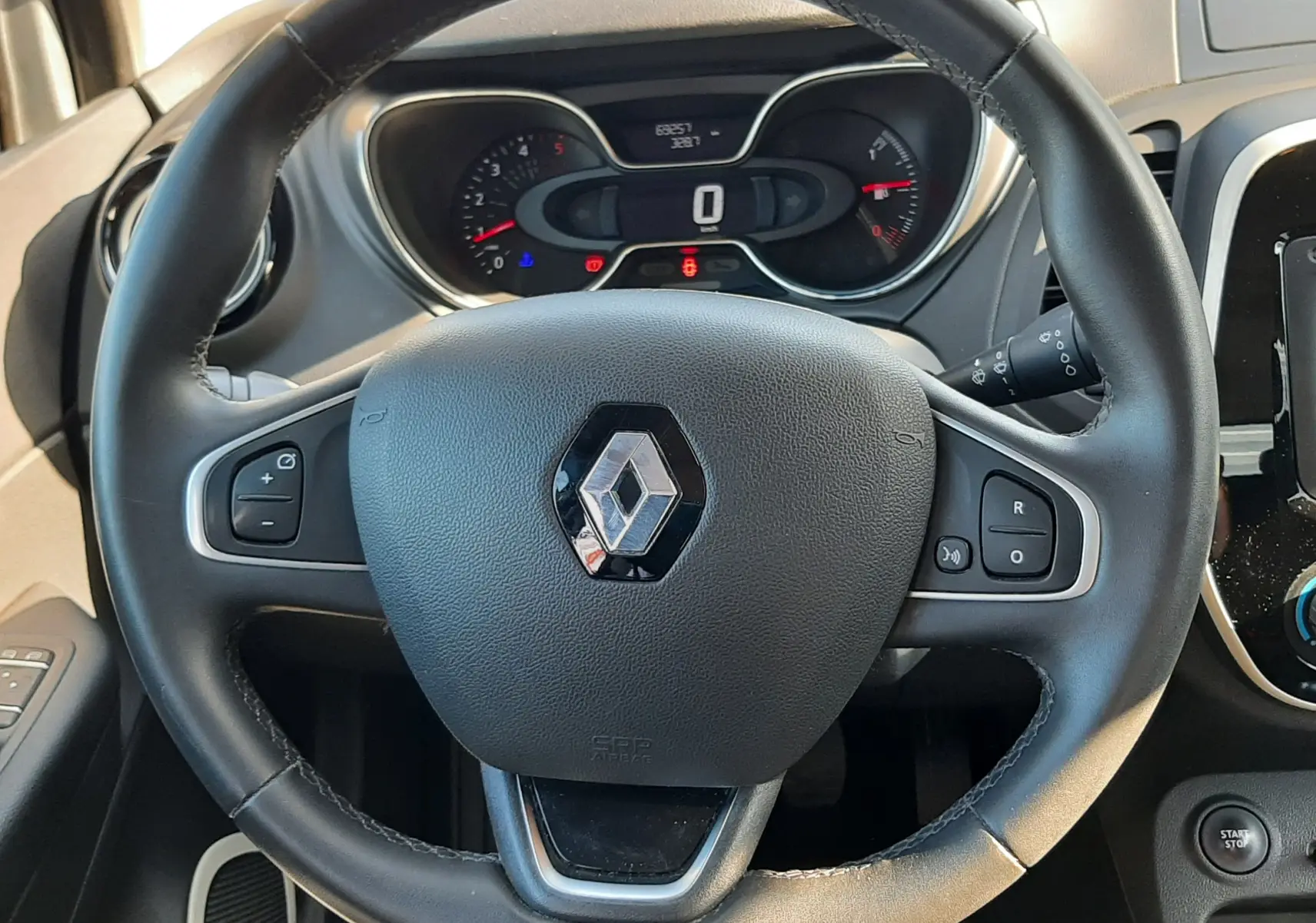 Vue plongeante sur la console centrale noire entre les sièges avant tissu du Renault Captur gris platine 2019.