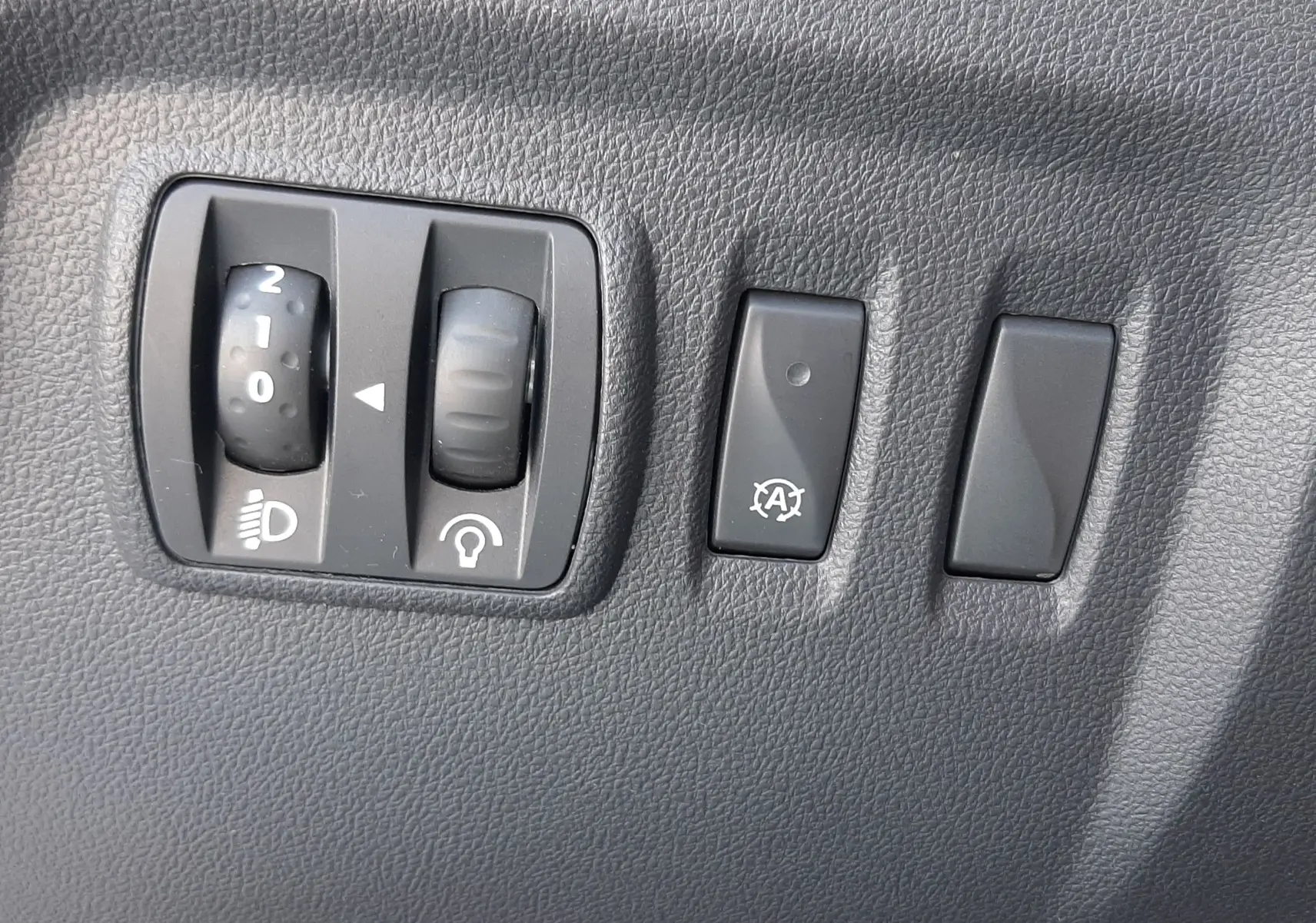 Gros plan sur la commande des vitres électriques et réglage des rétroviseurs côté conducteur d'un Renault Captur gris platine 2019.