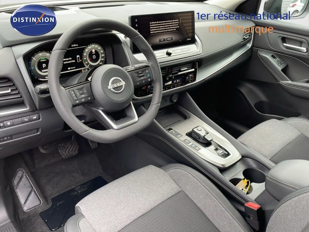 Intérieur du Nissan Qashqai 2025 gris, vue de l'habitacle côté conducteur avec tableau de bord digital et console centrale moderne.