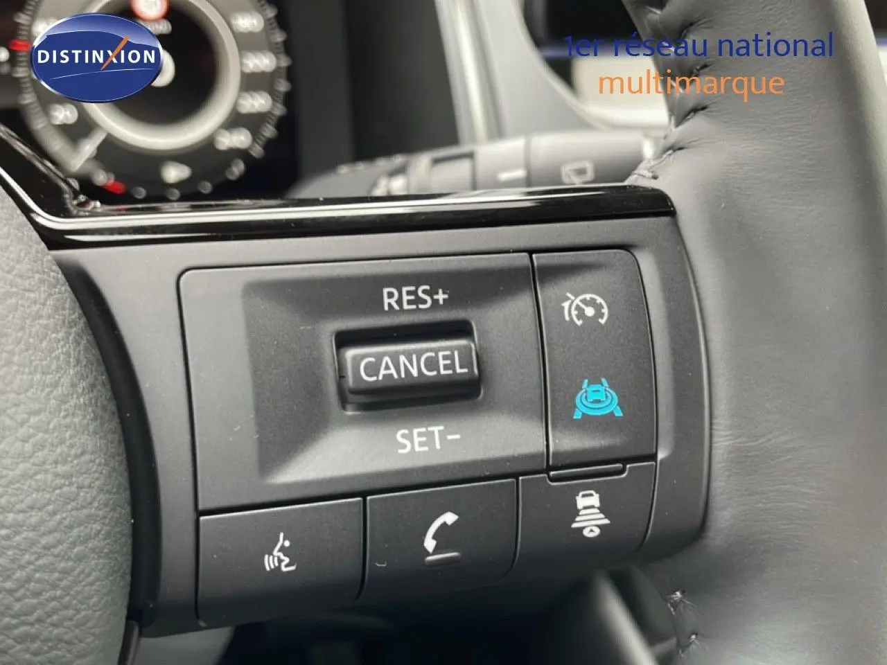 Gros plan sur les commandes au volant du Nissan Qashqai gris, avec régulateur de vitesse et aides à la conduite.