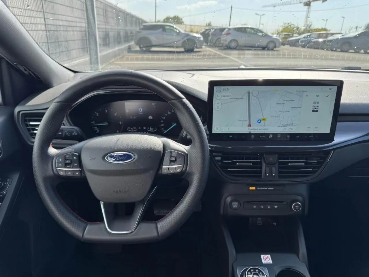 Vue intérieure avant de la Ford Focus IV ST-Line X, tableau de bord noir avec écran tactile large et volant multifonction.