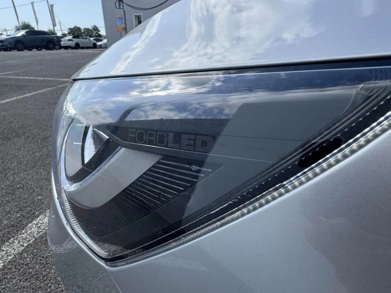 Gros plan sur le phare avant gauche gris Moondust Metal de la Ford Focus IV ST-Line X avec éclairage LED distinctif.