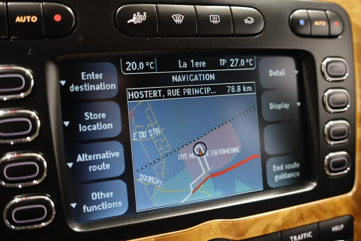 Gros plan sur l’écran de navigation intégré au tableau de bord en bois clair d’une Bentley Continental Flying Spur.