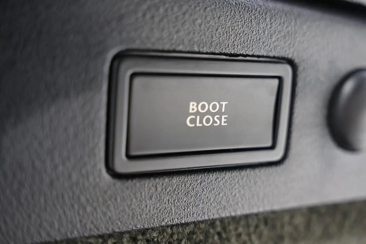 Gros plan sur le bouton "Boot Close" noir dans le coffre d'une Bentley Continental Flying Spur vert foncé de 2006.